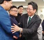 当選を確実にし、支持者と笑顔で握手する下鶴隆央さん＝２４日午後８時１３分、鹿児島市東千石町