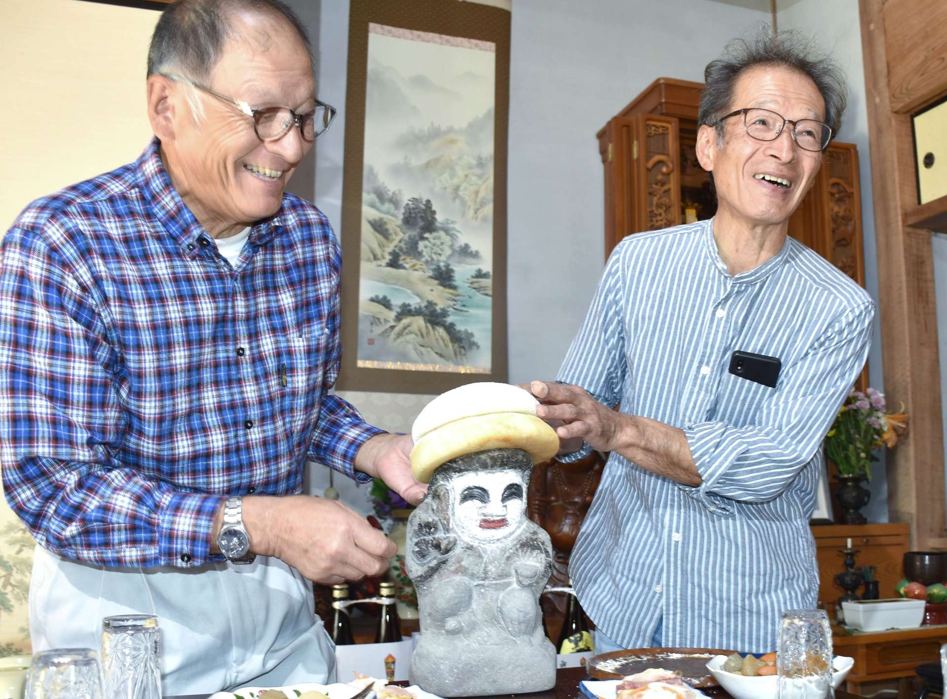 田の神に餅をかぶせる山花集落の住民ら＝姶良市北山