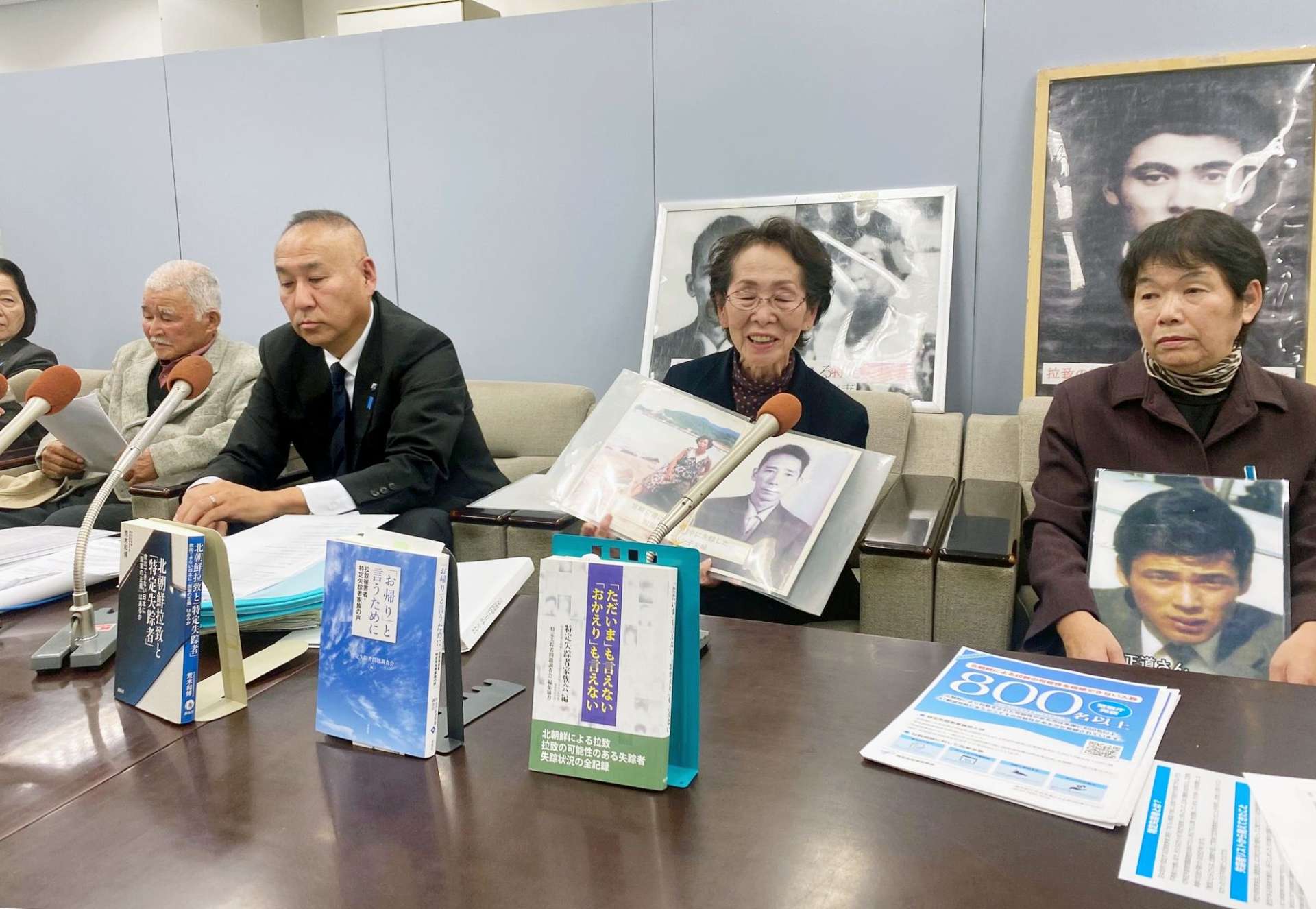失踪した両親の写真を示す前山利恵子さん（中央）＝２７日、鹿児島県庁