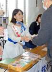 宝くじを手渡す「幸運の女神」の岡田桃果さん＝２８日、県庁
