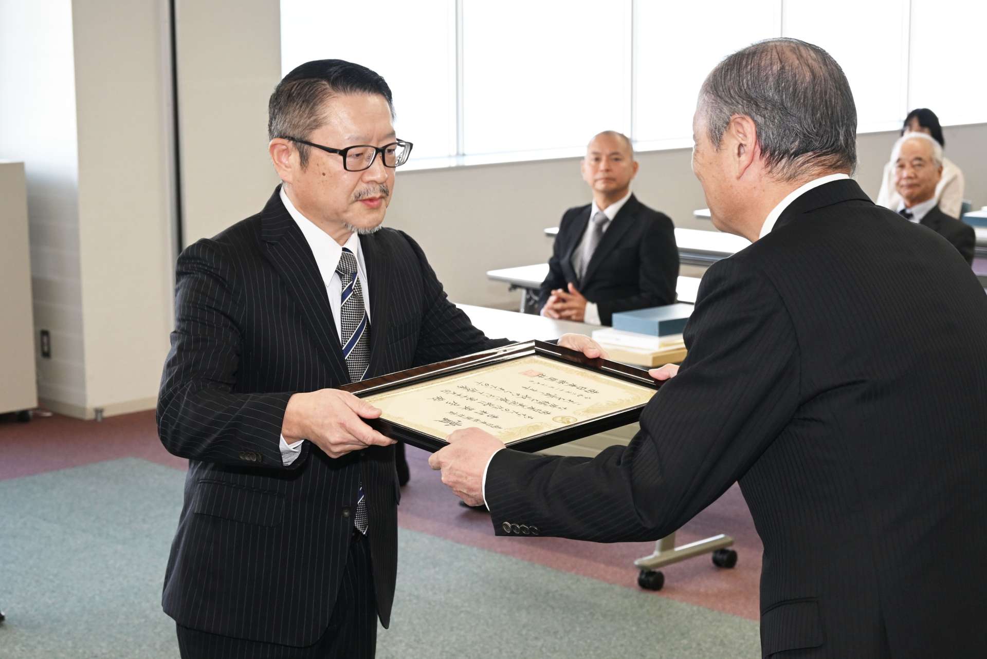 南日本新聞社賞の賞状を受け取る吉村英彦さん＝２９日、鹿児島市の南日本新聞会館（佐伯直樹撮影）