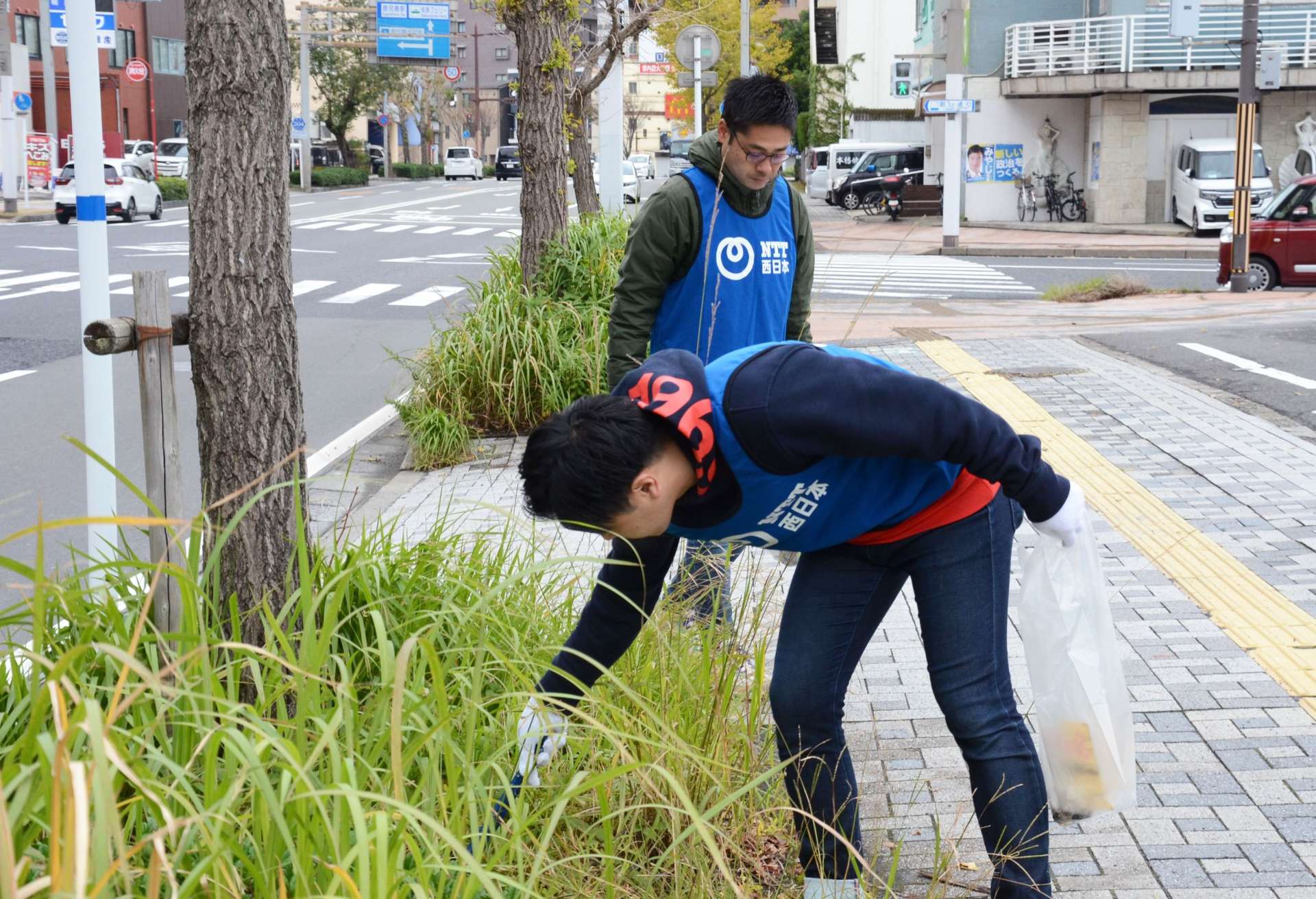 植え込みのごみを拾う参加者＝３０日、鹿児島市泉町