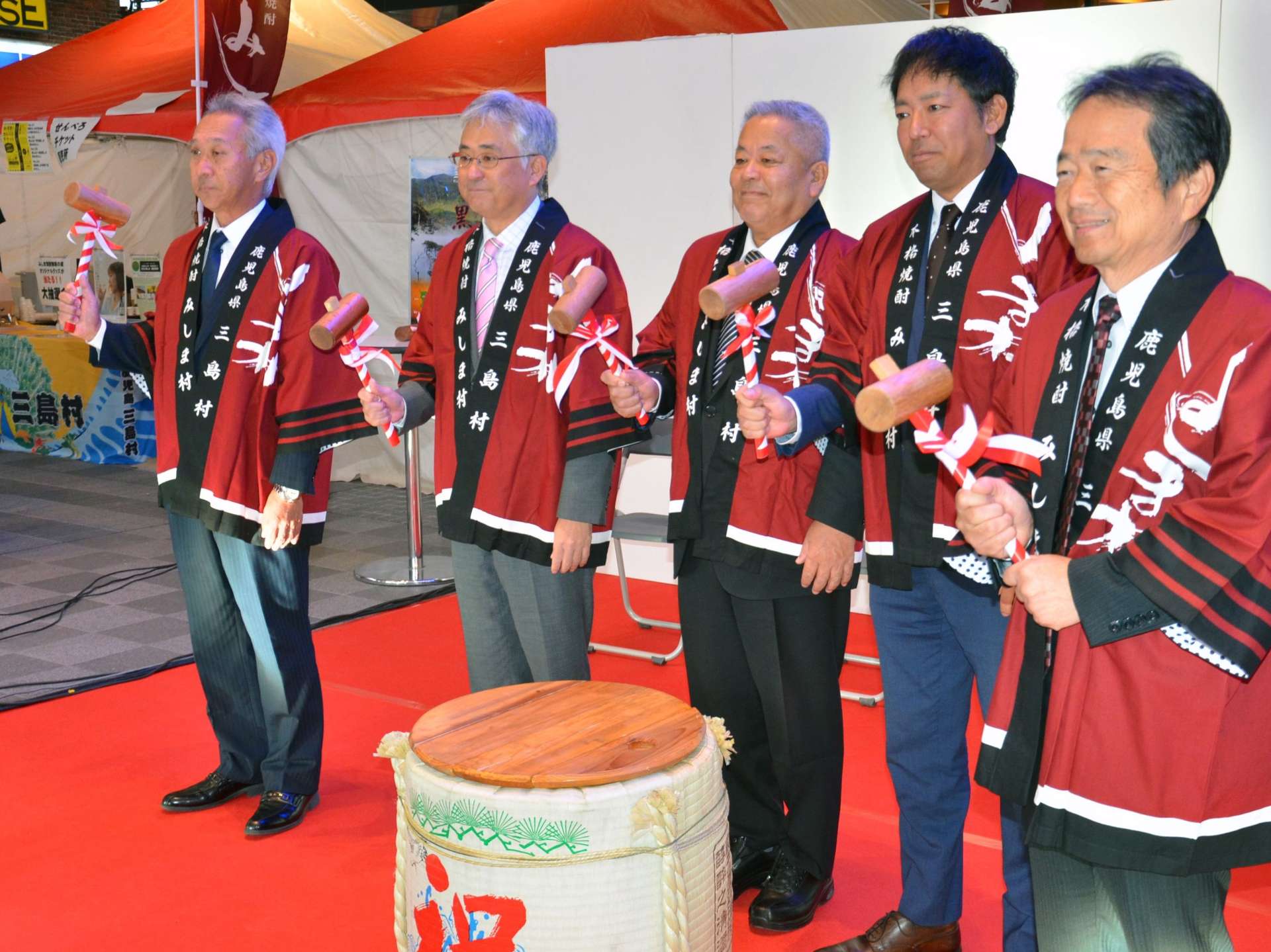 新焼酎完成を祝う三島村の大山辰夫村長（中央）＝３０日、鹿児島市のセンテラス天文館
