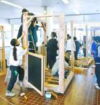 宮崎県産スギ材で木製列車を組み立てる都城高専の学生ら＝都城市松元町