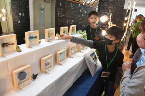 自ら制作した木工作品をＰＲする神川小学校の児童＝錦江町の神川中学校跡
