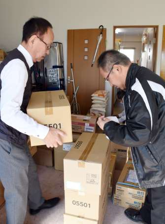 能登半島地震被災地に送る物資を準備するフードバンク大隅と郵便局長＝２５日、志布志市志布志町安楽