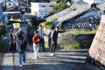 先輩移住者の案内で、石垣地区の町並みを見て回る参加者ら＝南九州市頴娃