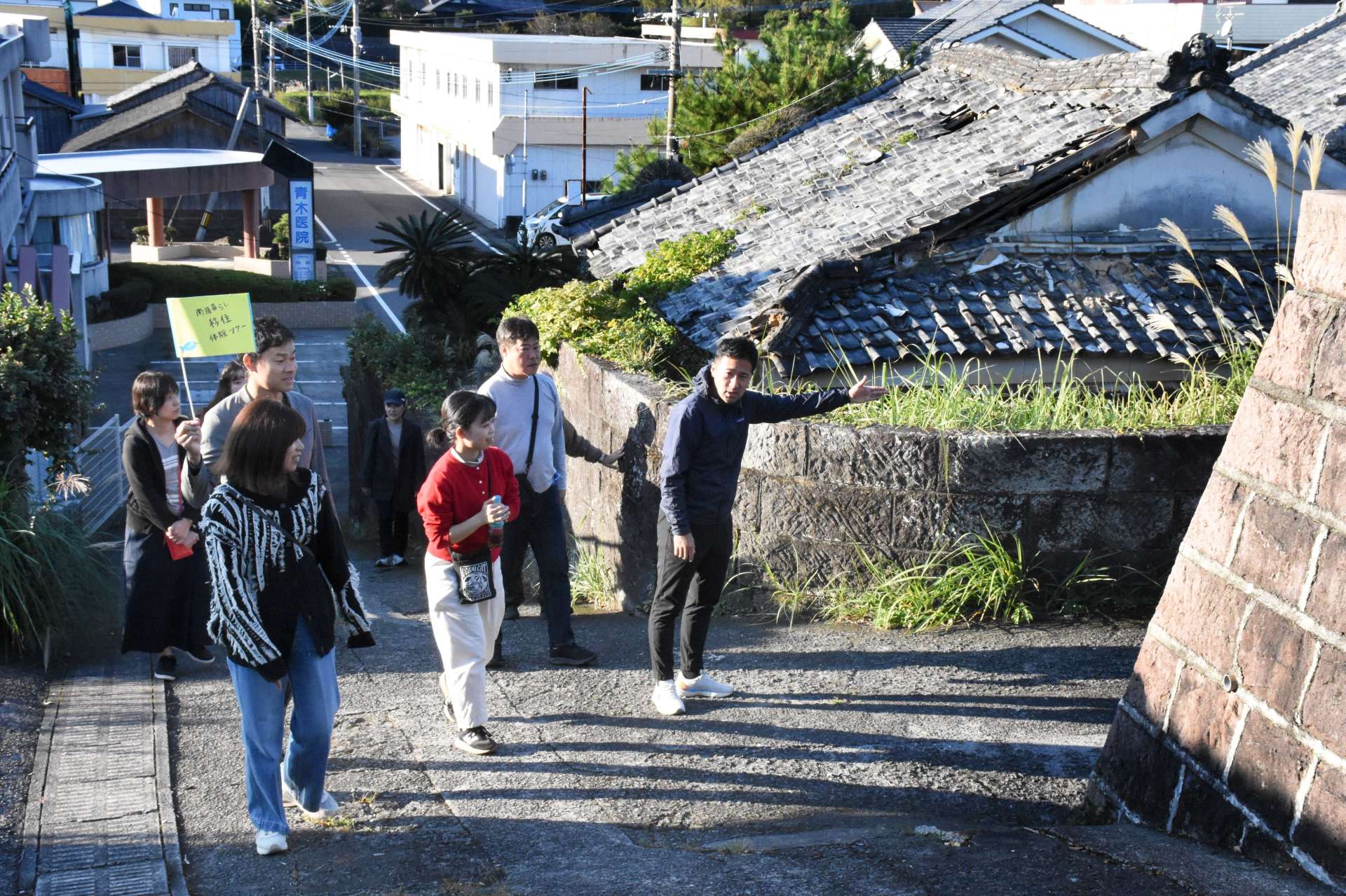先輩移住者の案内で、石垣地区の町並みを見て回る参加者ら＝南九州市頴娃