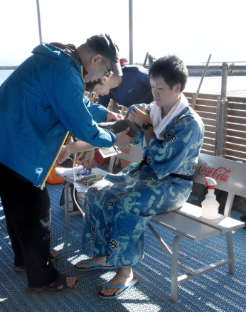 砂むし温泉の入浴前に測定機器を装着する被験者＝指宿市湯の浜５丁目