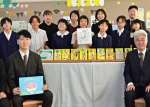 漫画とサイン色紙を寄贈を受けた児童と教員ら＝２５日、鹿児島市の鴨池小学校