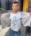 自作の絵をプリントしたＴシャツを見せるポヨヨン太郎さん＝鹿児島市名山町