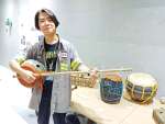 自作の民族楽器を手にする井之上隼三さん＝鹿児島市の天文館図書館