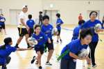 タグラグビーを楽しむ小学生＝志布志市の志布志運動公園体育館