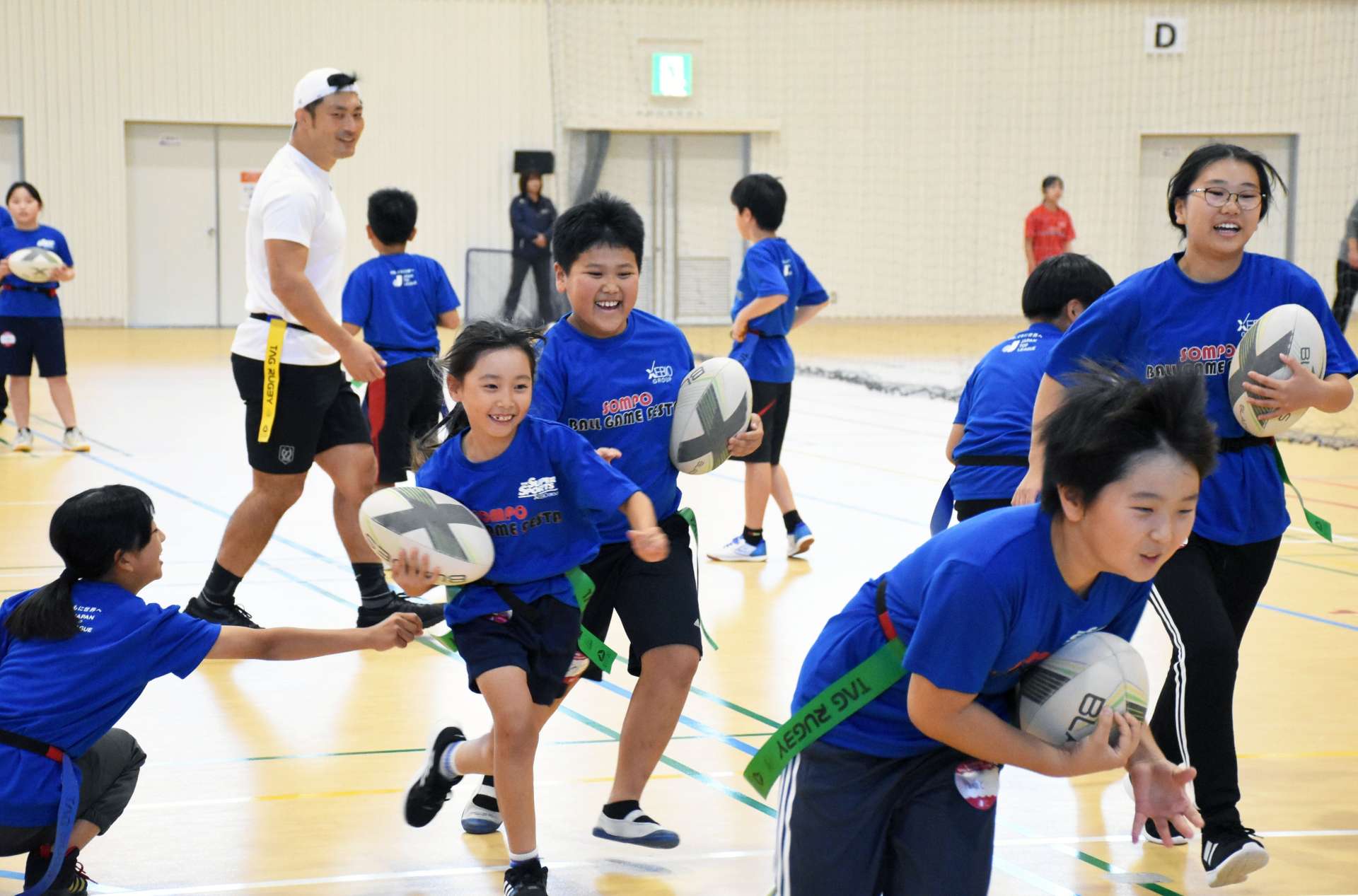 タグラグビーを楽しむ小学生＝志布志市の志布志運動公園体育館