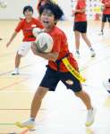 タグラグビーを楽しむ小学生＝志布志市の志布志運動公園体育館