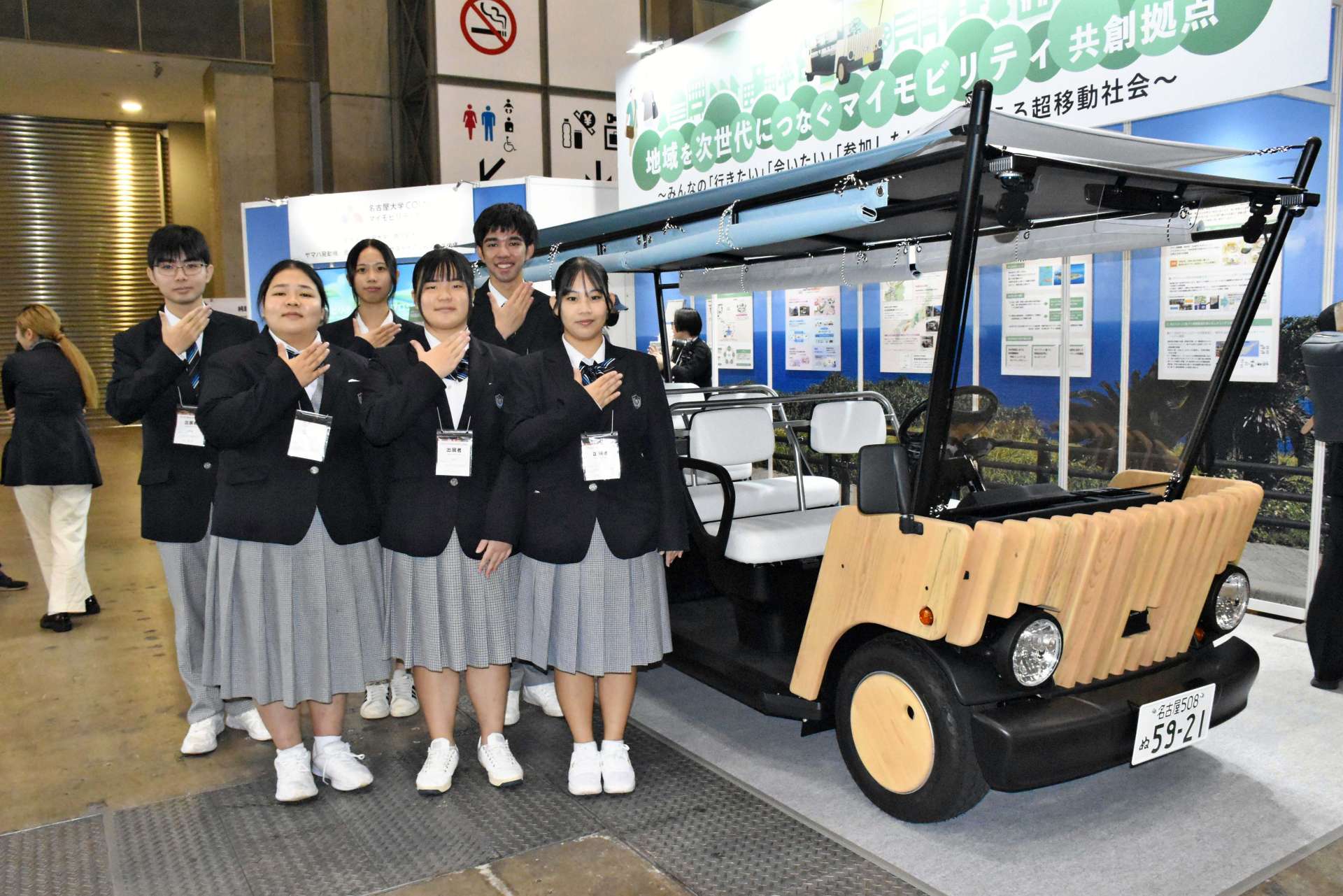 デザインに携わった車両を前に笑顔を見せる沖永良部高校３年生＝５日、東京・有明の東京ビッグサイト