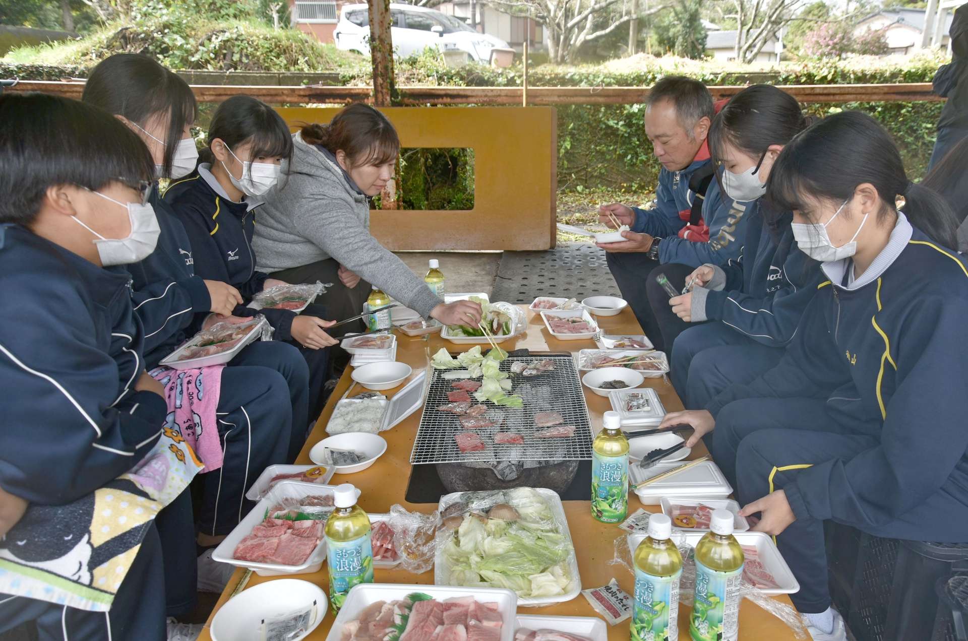 バーベキューを楽しむ中学生＝南大隅町の花ノ木家畜集合施設