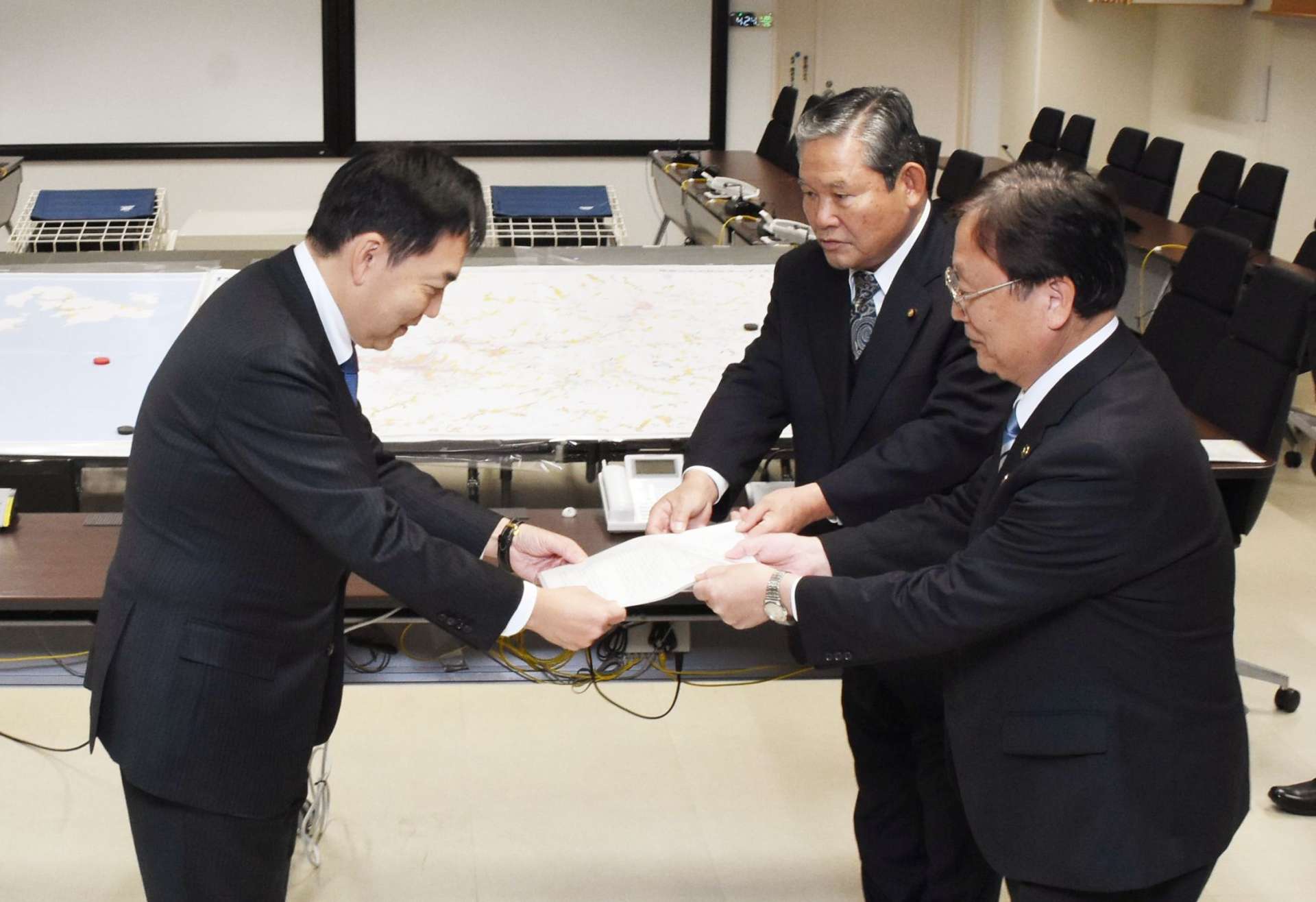浅尾慶一郎原子力防災担当相（左）に要望書を手渡す田中良二市長（右手前）ら＝８日、薩摩川内市役所