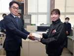 商品券を受け取る迫田桃華さん（右）＝１０日、枕崎市役所