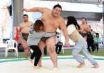 力士と相撲を楽しむ女性＝出水市のウイングドームいずみ