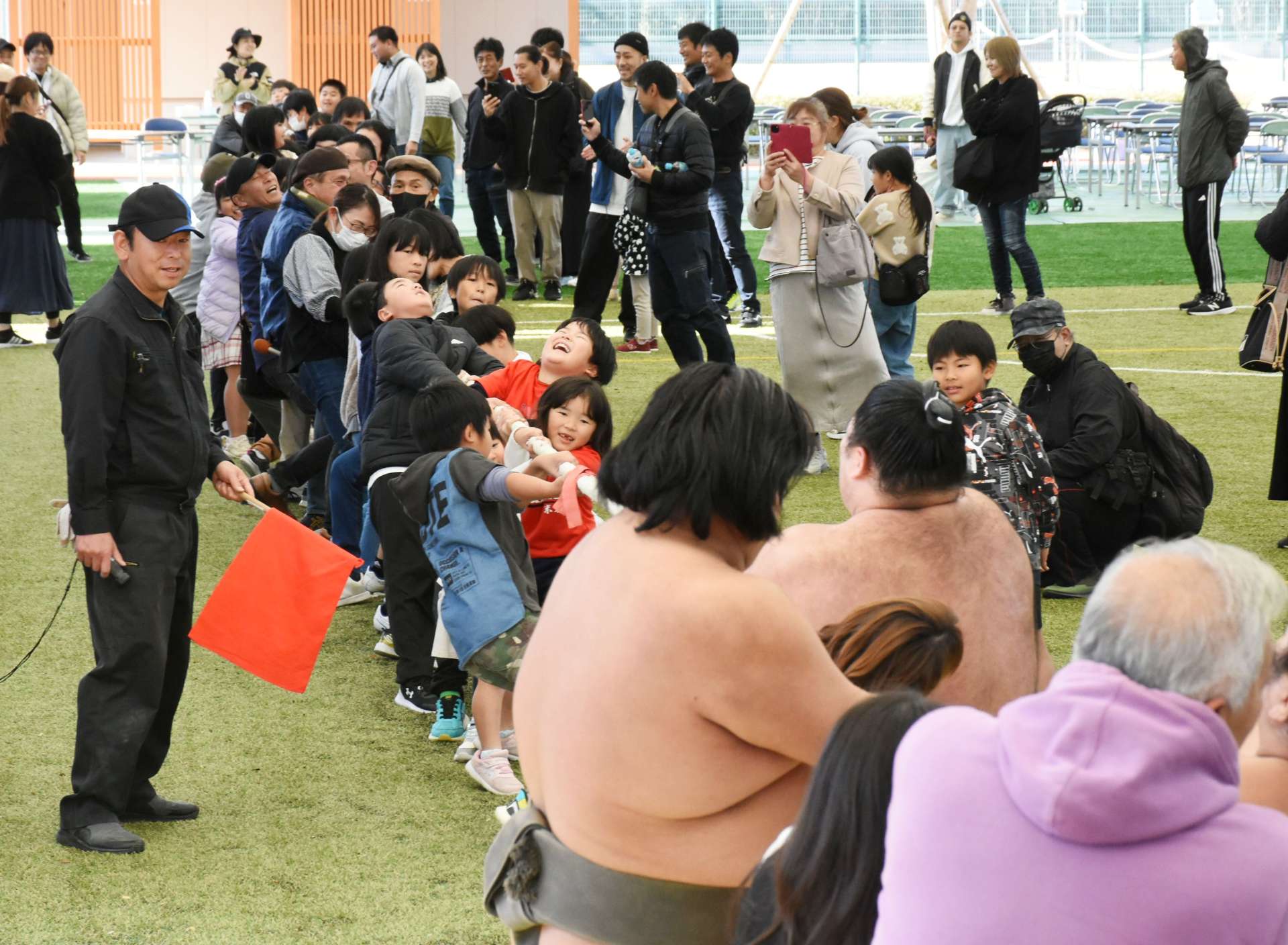 力士と綱引きを楽しむ参加者＝出水市のウイングドームいずみ