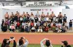 田子ノ浦親方（後列右から５人目）や力士と記念撮影する子どもら＝出水市のウイングドームいずみ