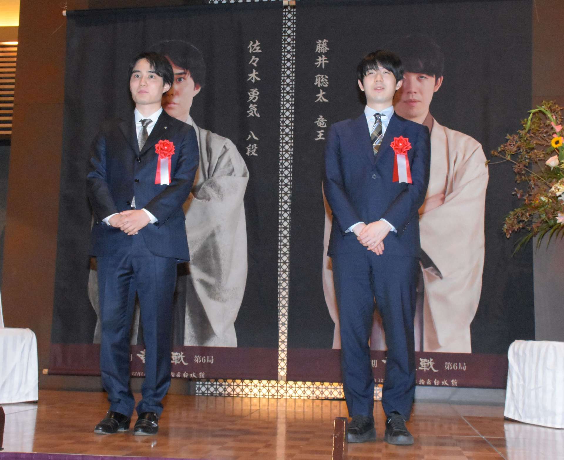 〈関連〉それぞれの写真パネルの前に立つ藤井聡太竜王（右）と挑戦者の佐々木勇気八段＝１０日、指宿市の薩摩伝承館