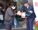 拉致事件のチラシを手渡す日置警察署の小林正樹署長＝１１日、日置市東市来の江口蓬莱館