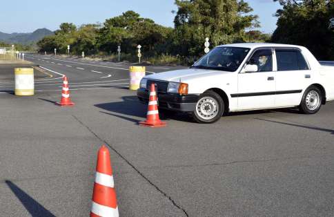 コースを曲がり切れず、カラーコーンに接触する車＝９日、姶良市の県運転免許試験場