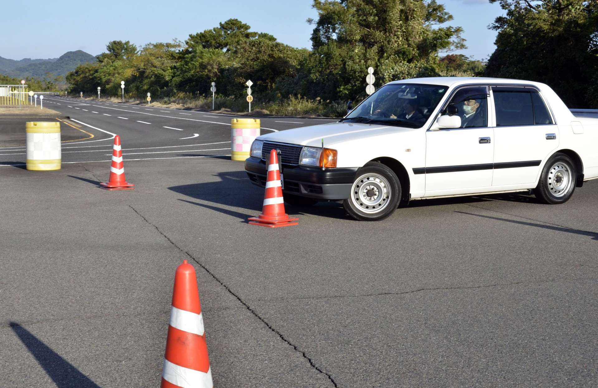 コースを曲がり切れず、カラーコーンに接触する車＝９日、姶良市の県運転免許試験場