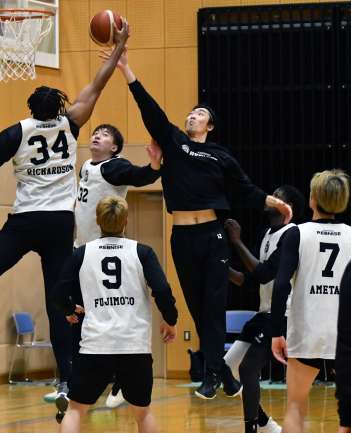 試合形式の練習でシュートブロックに跳ぶ藤田＝鹿児島市の郡山体育館
