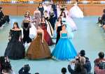 苦労して仕上げたドレスを披露する生徒たち＝南九州市知覧の薩南工業高校