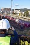 脱線した列車を撮影する運輸安全委員会の鉄道事故調査官＝１２日、薩摩川内市