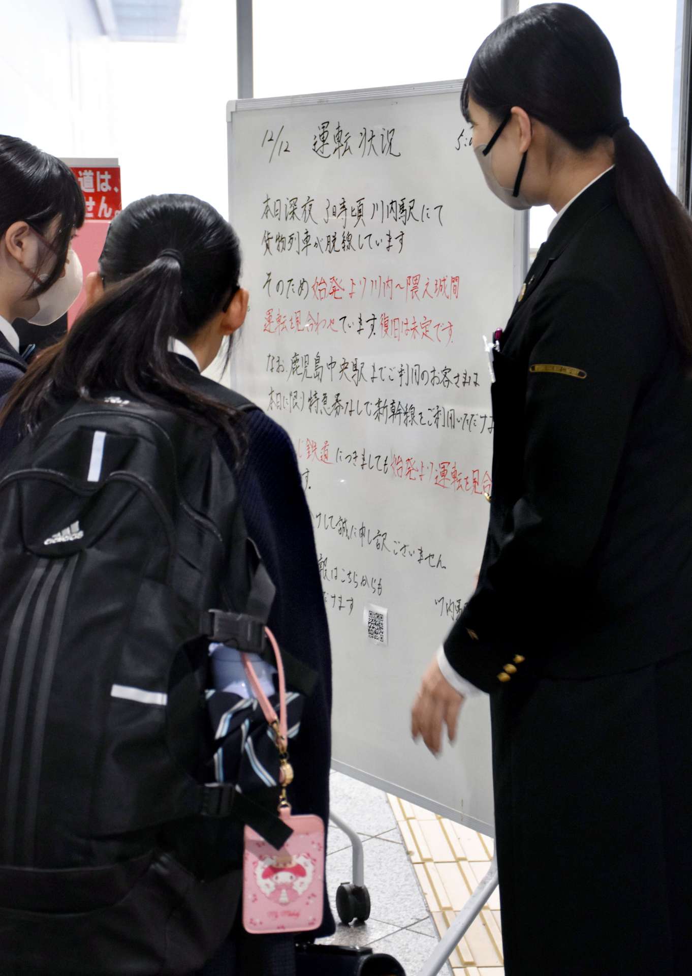 運休見合わせの掲示に見入る利用者ら＝１２日午前７時３５分ごろ、薩摩川内市の川内駅