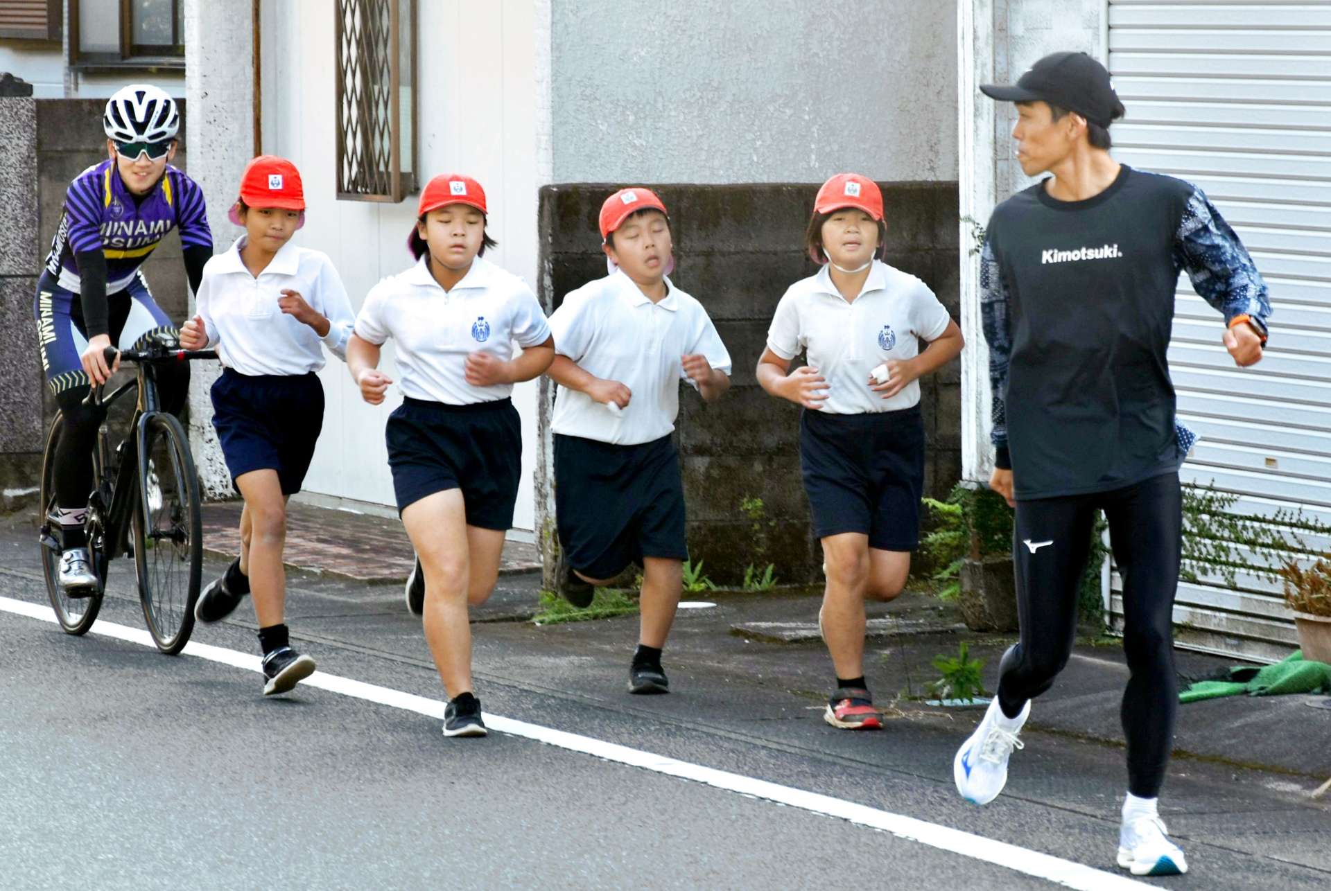 神山小学校児童と併走する県下一周駅伝ランナーら＝南大隅町根占川北