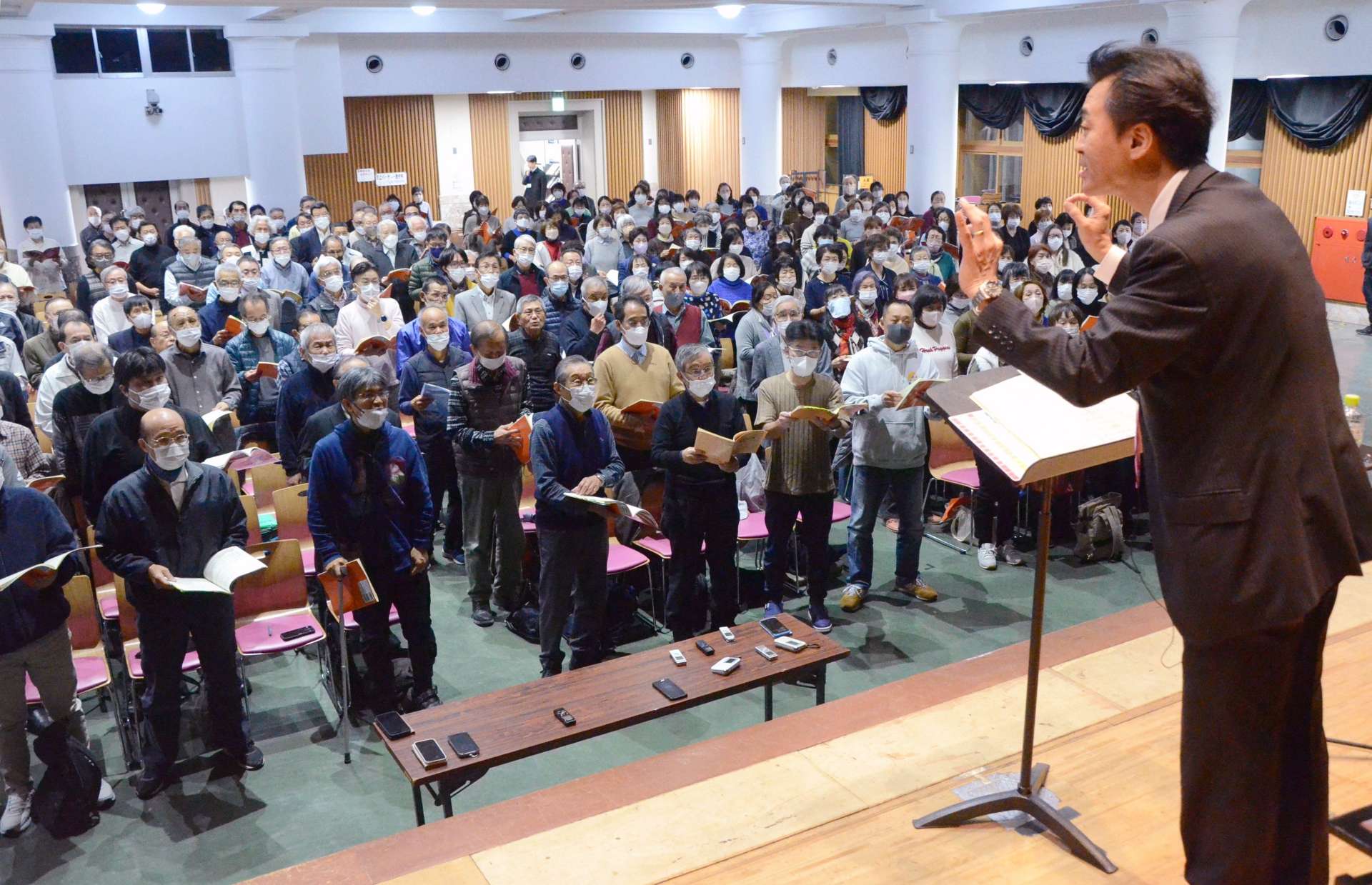 藤本淳也さんの指揮に合わせ、練習に励む合唱団のメンバー＝鹿児島市の中央公民館