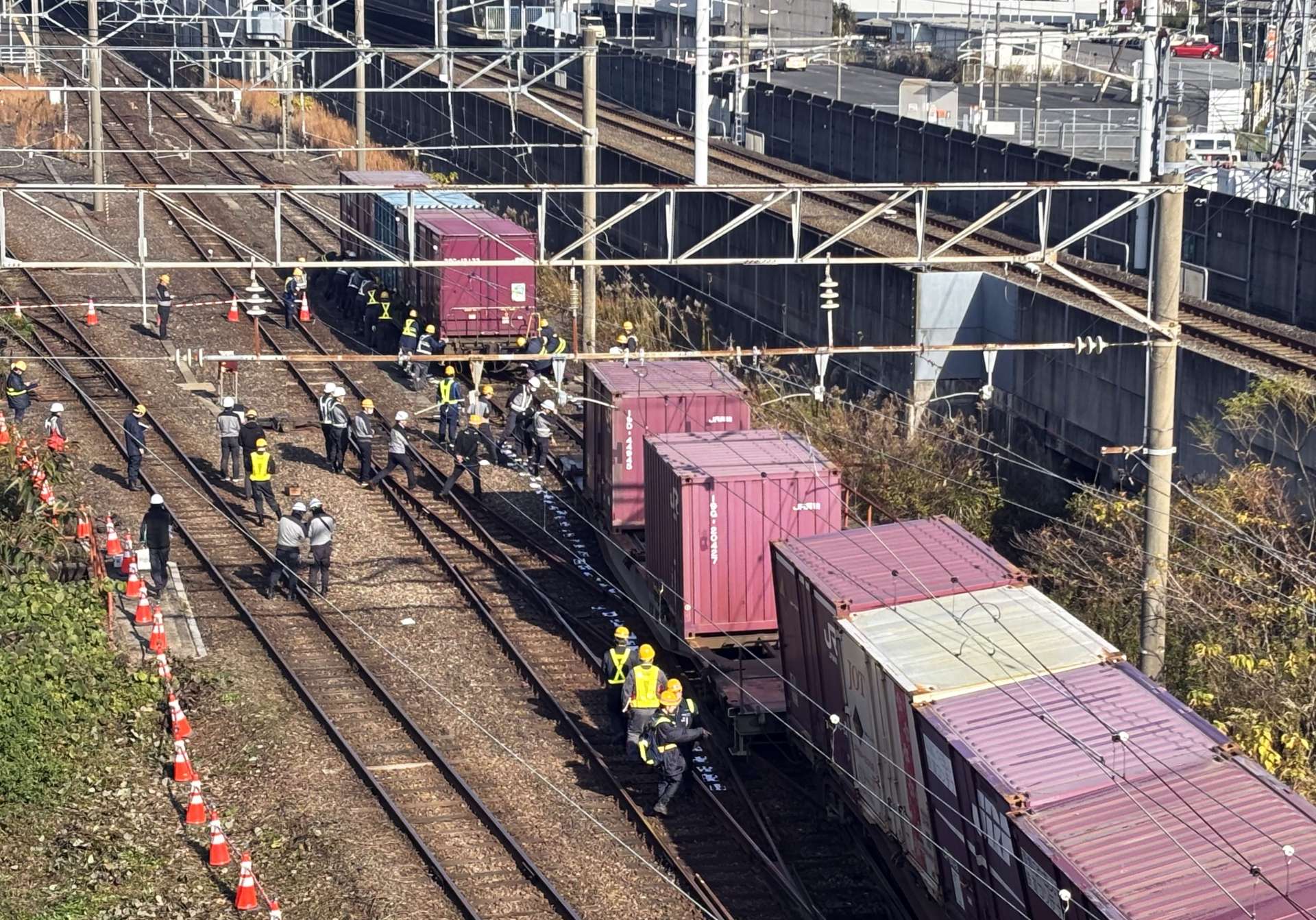 脱線した貨物列車の後方の車両を切り離して移動させる作業員ら＝１３日午前１０時半ごろ、薩摩川内市の川内駅