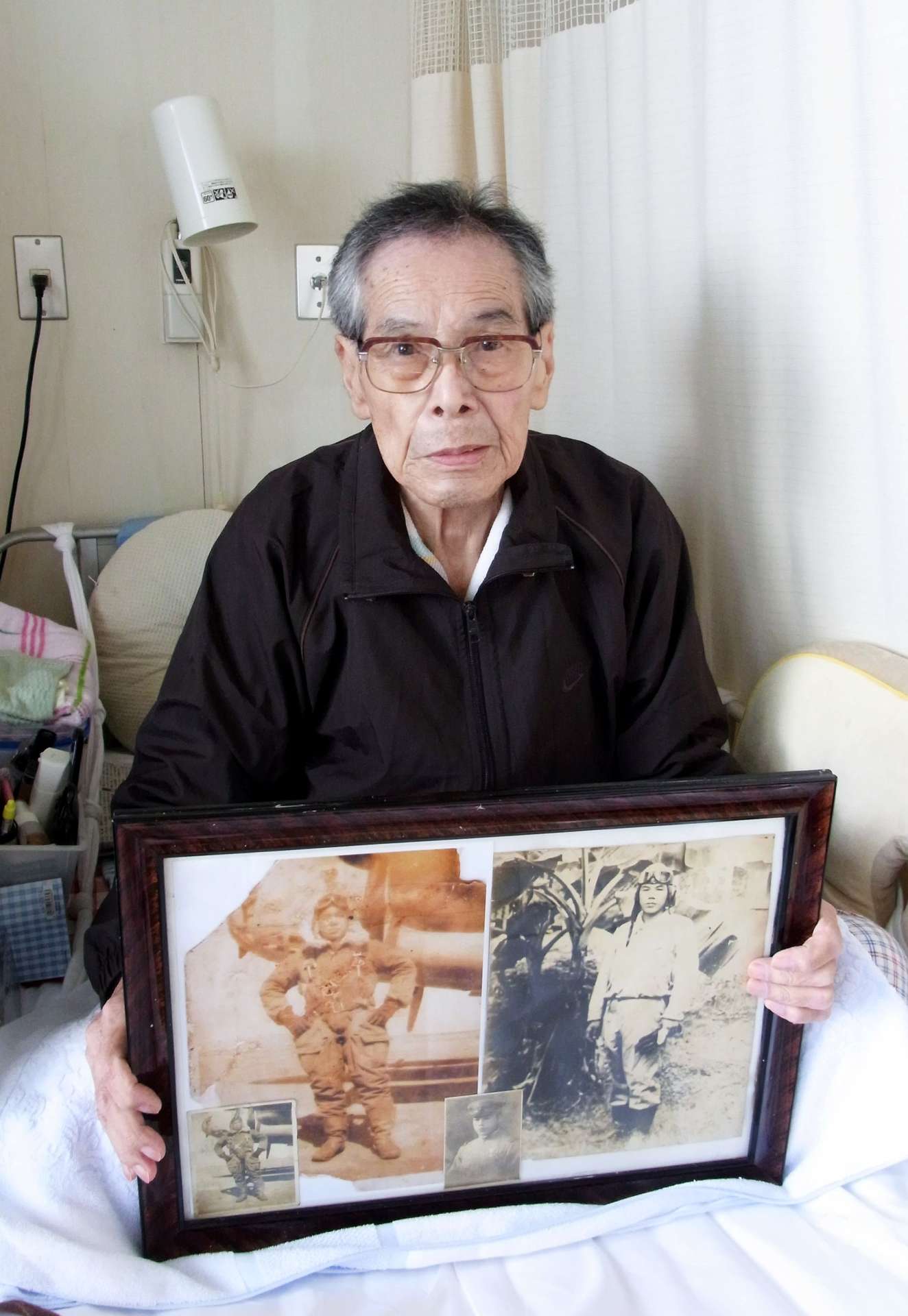 飛行服姿の写真を手に、南方の戦いを振り返る松永清次さん＝志布志市志布志