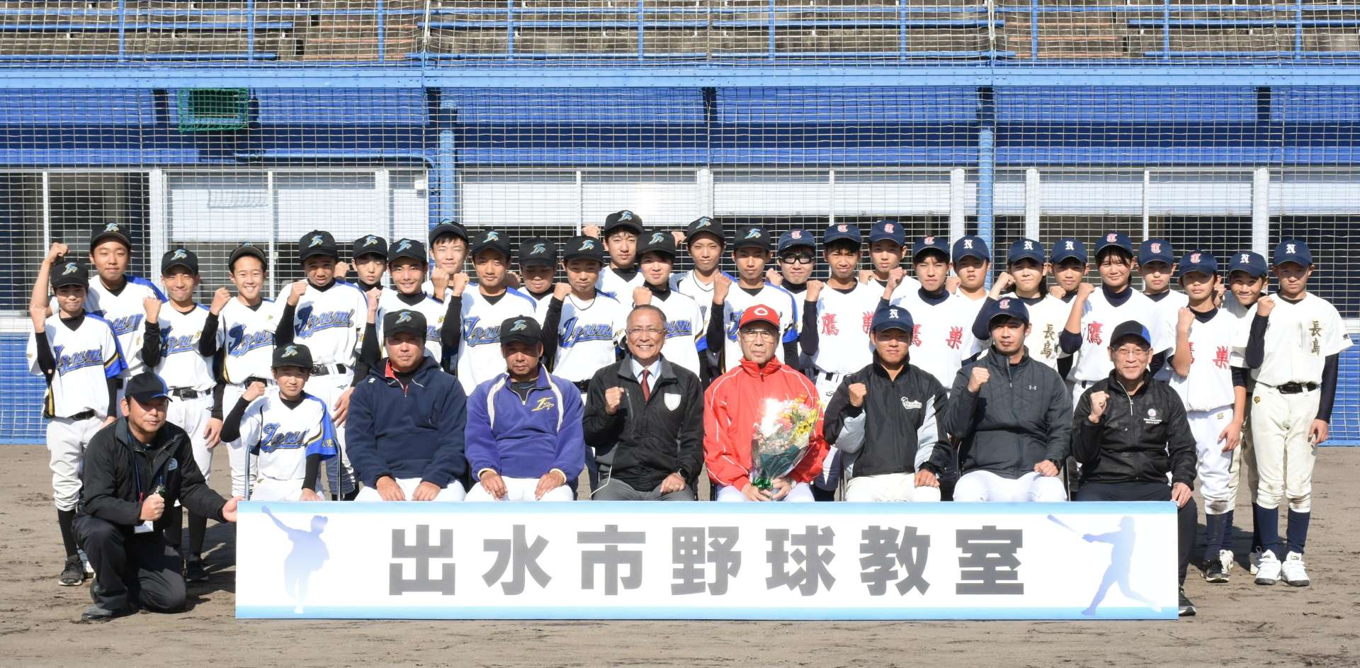 外木場義郎さん（前列右から４人目）を囲み笑顔の選手ら＝７日、出水市中央町
