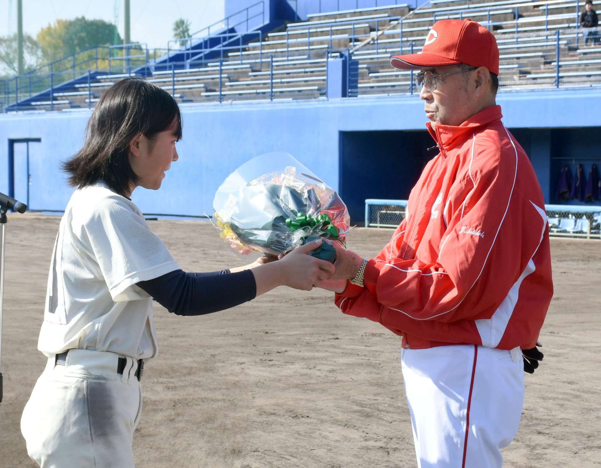 選手から花束を贈られる外木場義郎さん（右）＝７日、出水市中央町