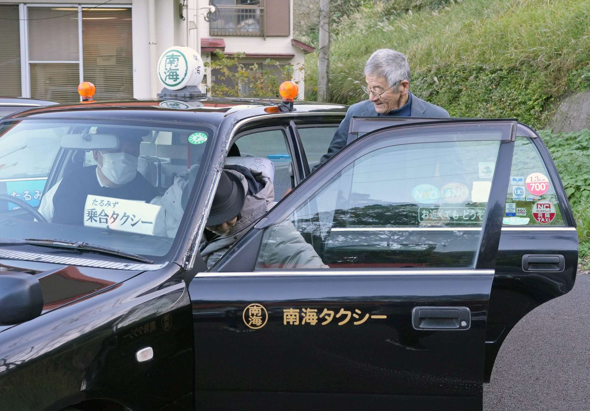 乗り合いタクシーに乗車する地域住民ら＝垂水市牛根境の境地区公民館