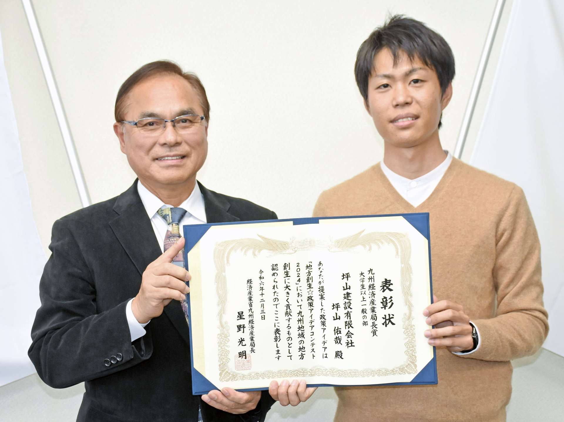 下平晴行市長に九州経済産業局長賞受賞を報告する坪山佑哉さん（右）＝志布志市役所