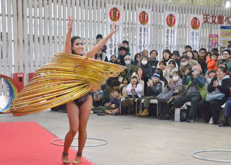 フラフープを使った演技を披露する木下大サーカスの団員＝１５日、鹿児島市の天文館ベルク広場