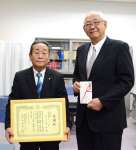 寄付金を贈った鹿児島県タクシー協会の下之角洋会長（左）＝１６日、県庁