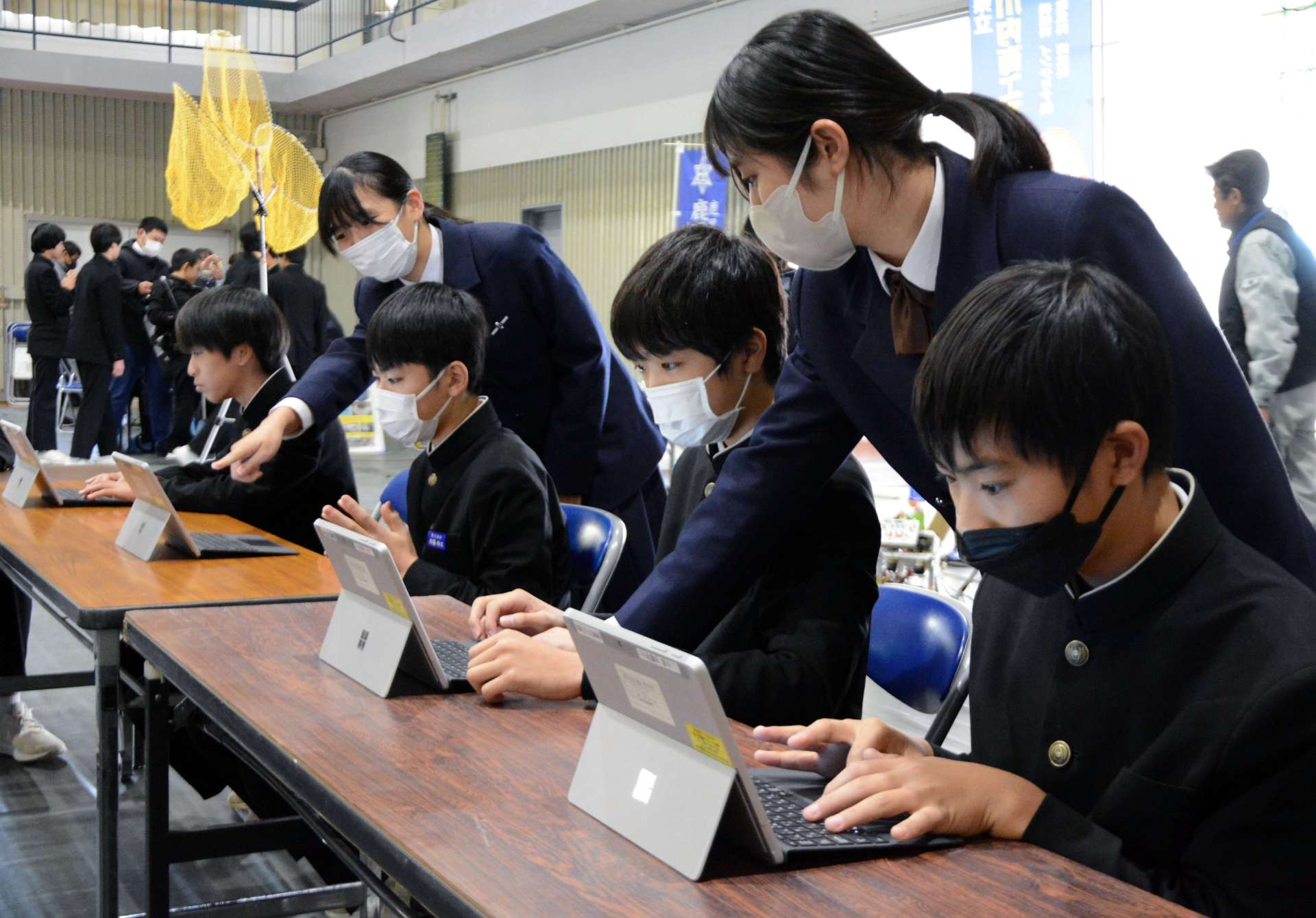 高校生に教わりながらタイピングソフトを楽しむ中学生＝さつま町虎居