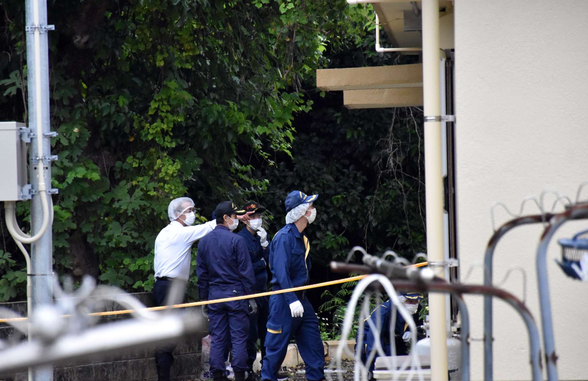 １１月２１日午後、現場付近を捜査する警察官＝伊仙町佐弁