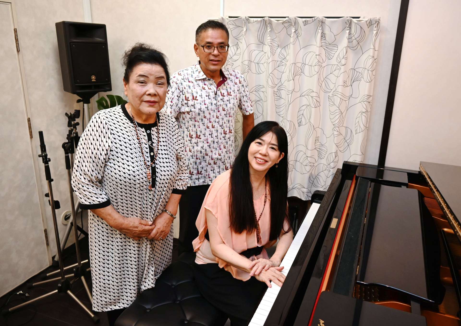 「緑の島のお墓」を録音した（左から）黒木イツ子さん、猛さん親子と、伴奏の柴藤ひろ子さん＝鹿児島市桜ケ丘３丁目