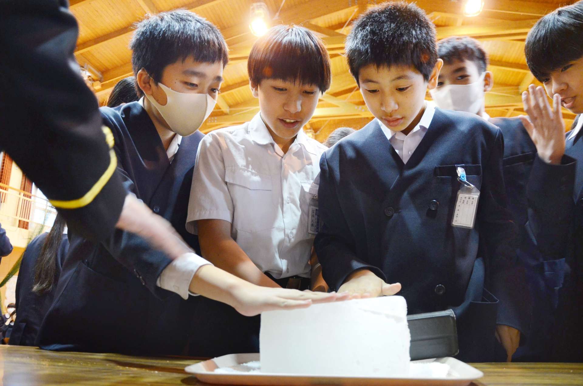 南極の氷に触れる児童たち＝１３日午後２時ごろ、鹿児島市平川町の福平小学校