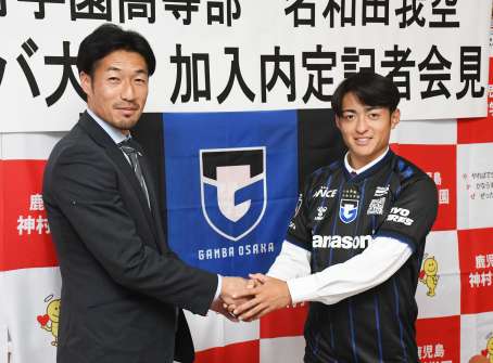 〈関連〉ガンバ大阪加入が内定し、青木良太スカウト（左）と握手する神村学園高の名和田我空＝１７日、いちき串木野市の同校