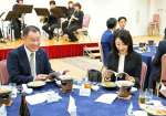 ５００回記念誌を読みながら歓談する会員ら＝１７日、鹿児島市与次郎一丁目の鹿児島サンロイヤルホテル